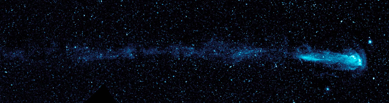 An ultraviolet image from NASA's GALEX telescope showing the red giant Mira as the bright head at the right end, trailing a comet-like tail of shed gas 13 light-years long behind it.