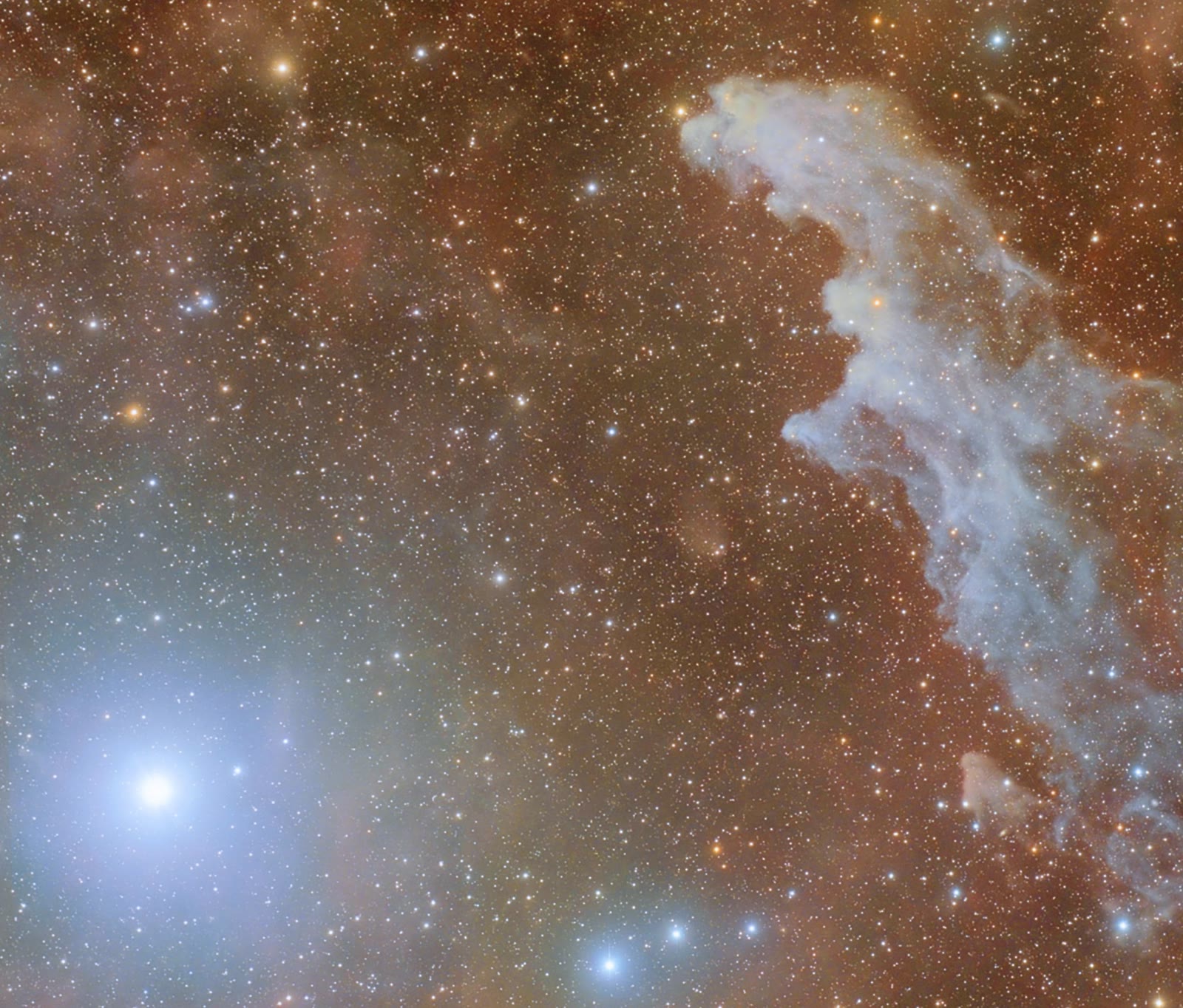 Rigel, the blue supergiant at Orion's foot, glows at lower left and lights up the Witch Head Nebula, the pale cloud on the right that looks like a witch's profile.