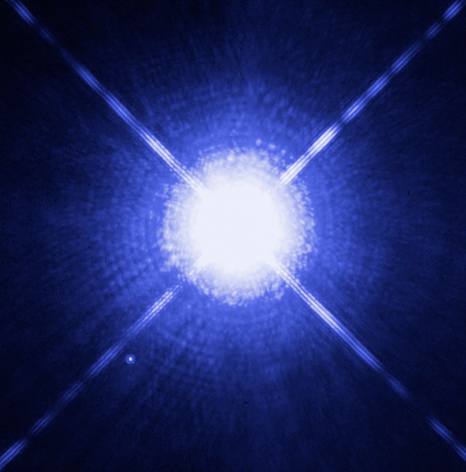 A Hubble Space Telescope image of Sirius, deliberately overexposed in the centre so that its tiny white-dwarf companion, Sirius B, shows as the faint dot at lower left.